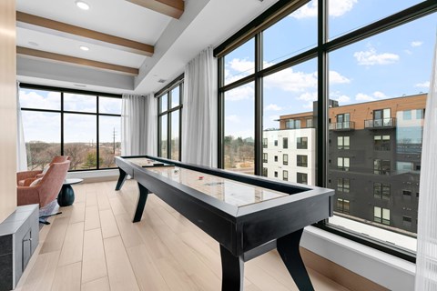 A pool table in a room with a view of the city.