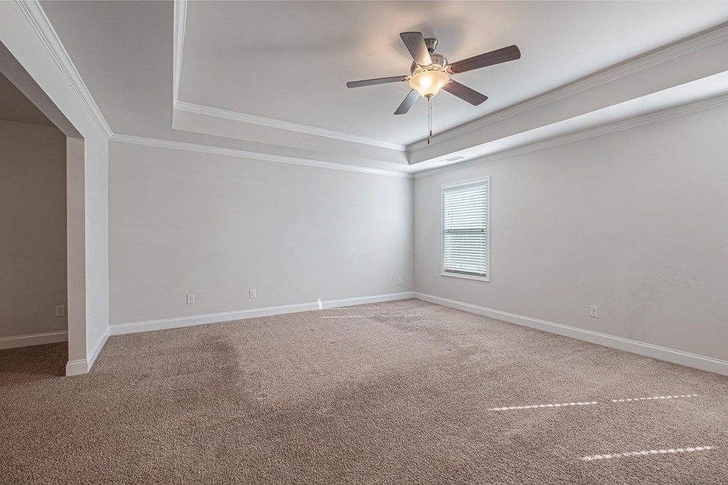 an empty living room with a ceiling fan