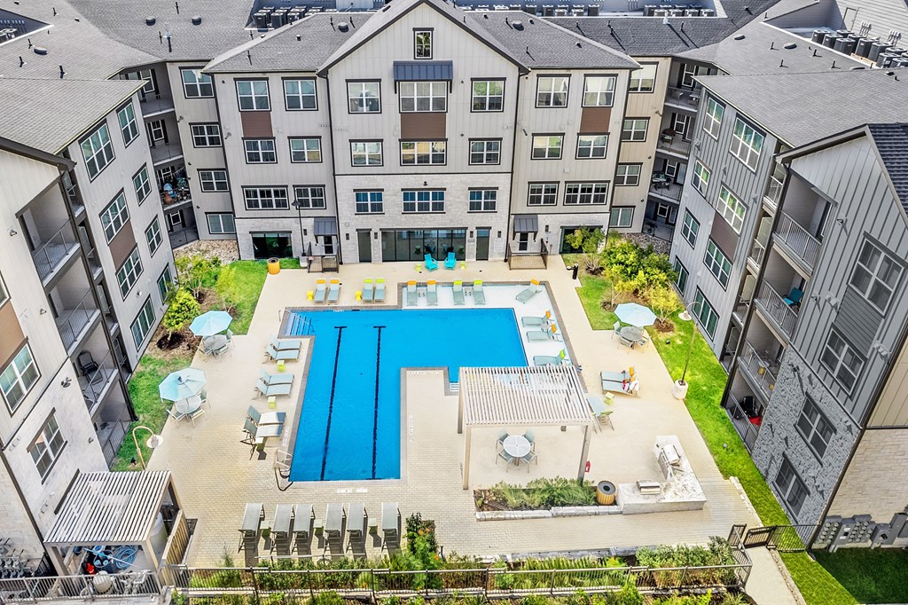 an aerial view of an apartment building with a swimming pool