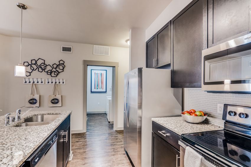 luxury kitchen with granite countertops, stainless steel appliances, and dark wood cabinetry