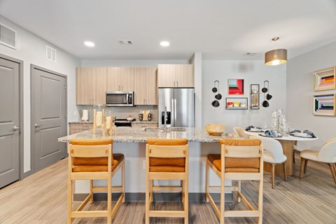 A kitchen with a table and chairs.