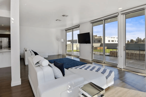 A modern living room with a white sofa and a television.