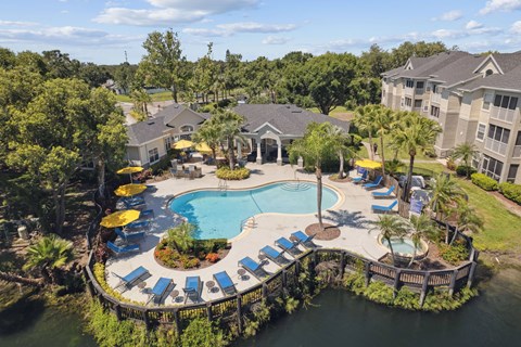 An aerial view of a resort with a pool and loungers.