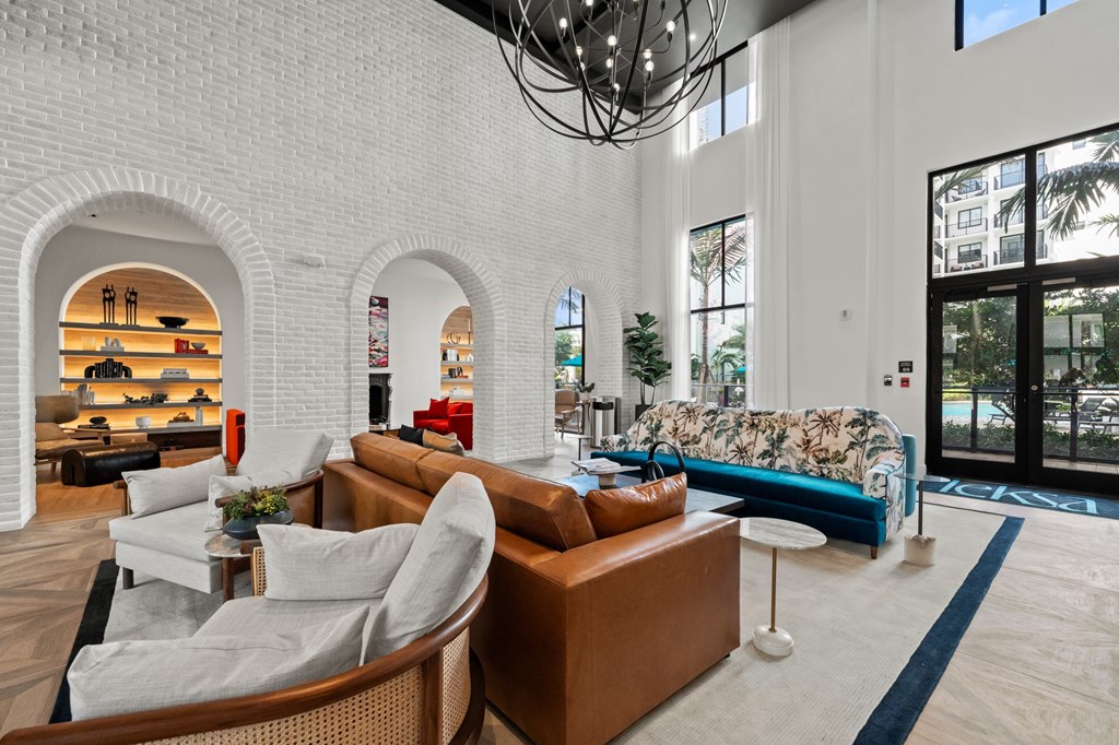 A living room with a white brick wall and a large window.