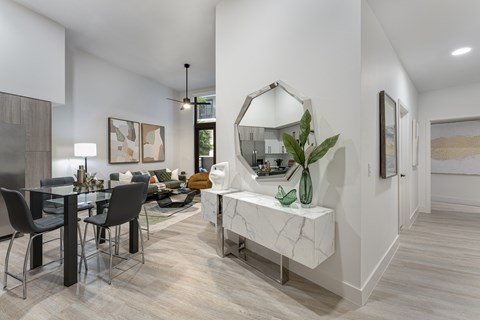 A modern dining room with a marble bench and a large mirror.