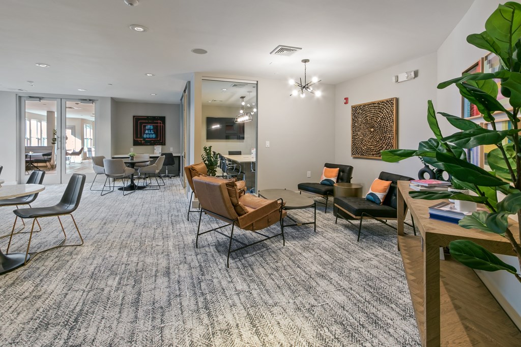 an open living room with chairs and tables and a dining room table and chairs