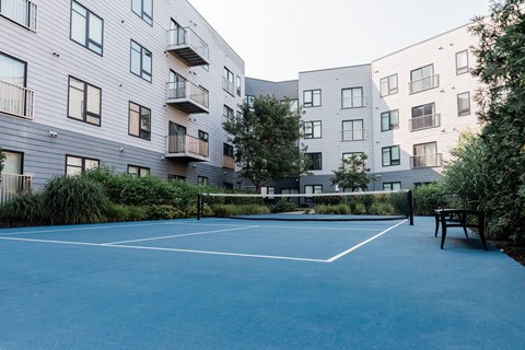 A tennis court is located in front of a building.