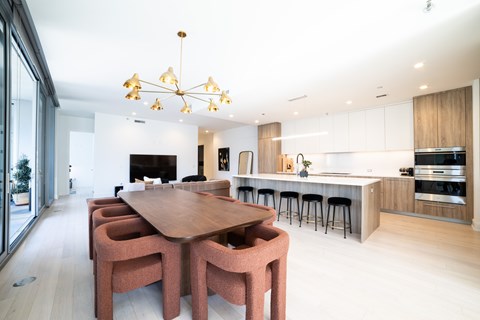 a dining room and kitchen with a wooden table and chairs