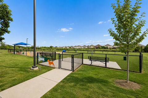 A park with a playground and a fence.