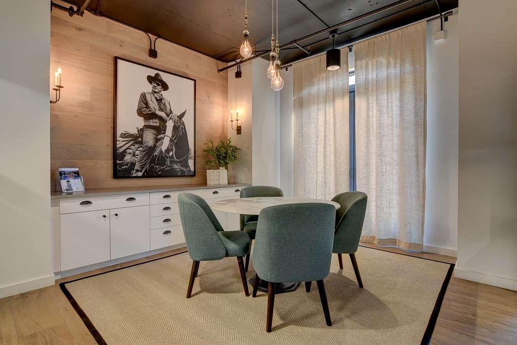 a dining room with a table and chairs and a painting on the wall