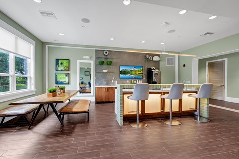A modern kitchen with a bar area and a dining table.