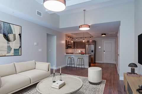 A living room with a white couch and a bar area in the background.