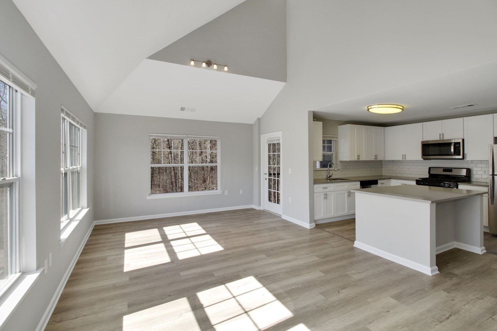 a living room with a kitchen and a large window