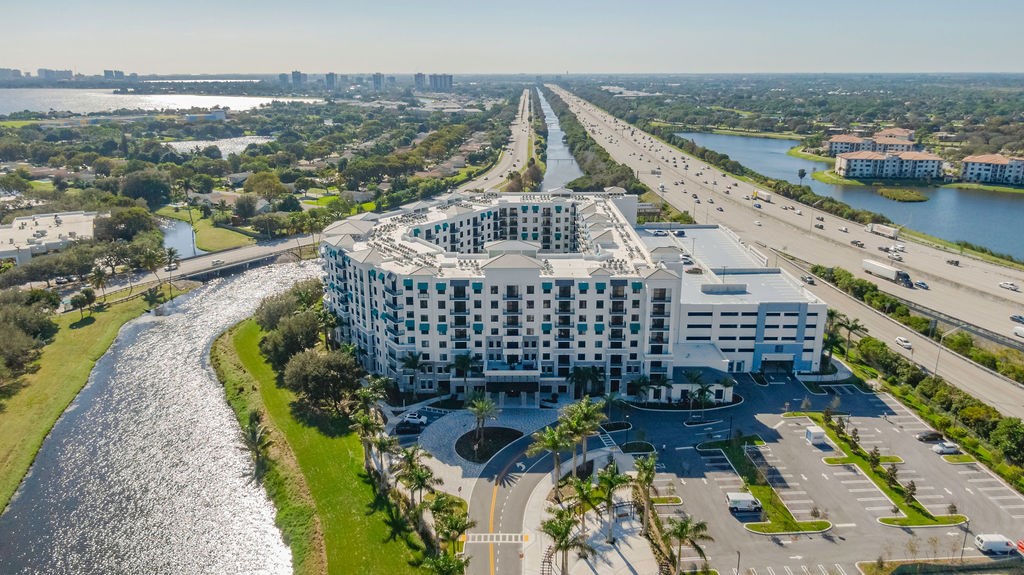 an aerial view of a building next to a highway and a river