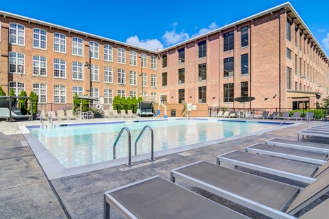A large swimming pool in front of a brick building.