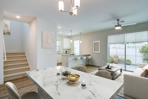 A modern dining room with a marble table and chairs.