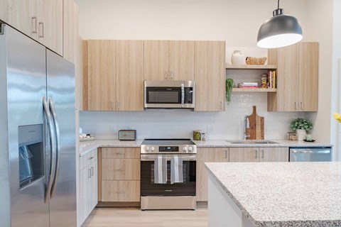 A modern kitchen with wooden cabinets and stainless steel appliances.
