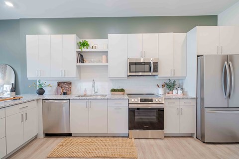 A modern kitchen with white cabinets and stainless steel appliances.