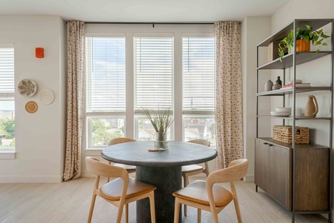 A dining room with a round table and chairs.