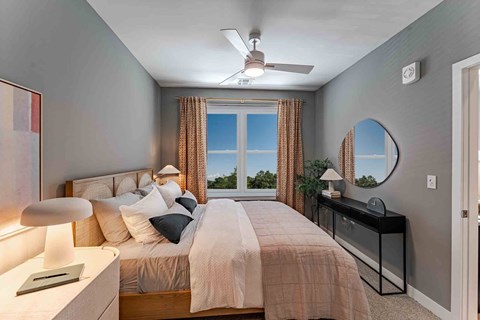 A bedroom with a large bed and a ceiling fan.
