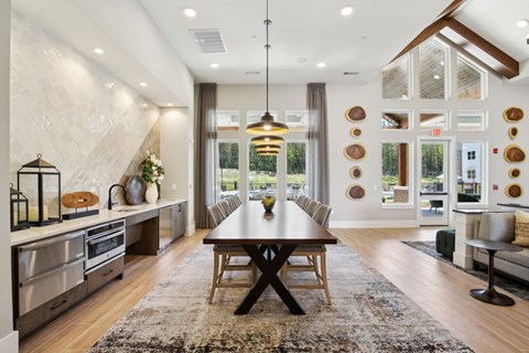 A modern kitchen with a dining table and chairs in the middle of the room.