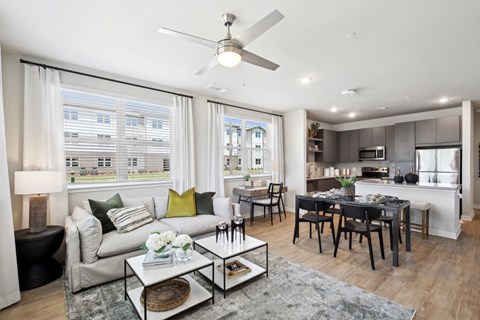 A modern living room with a glass coffee table and a dining table with chairs.