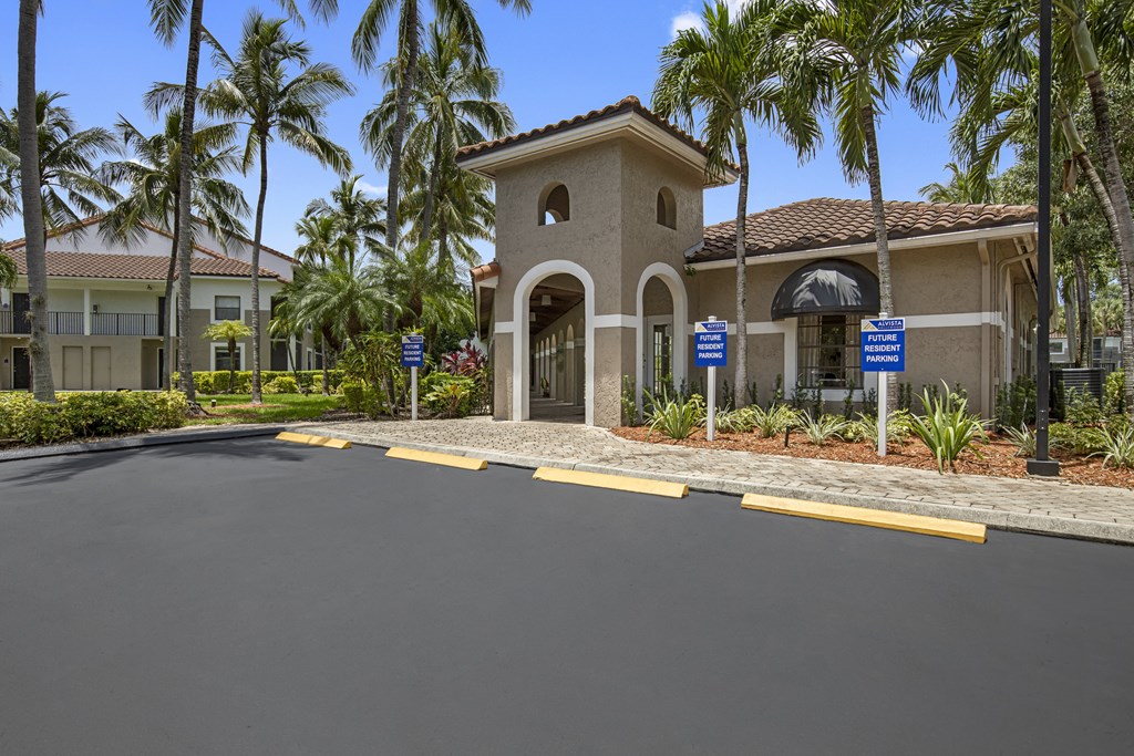 a home with a driveway and palm trees in the background