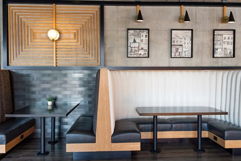 A modern dining area with a wooden table and black leather chairs.