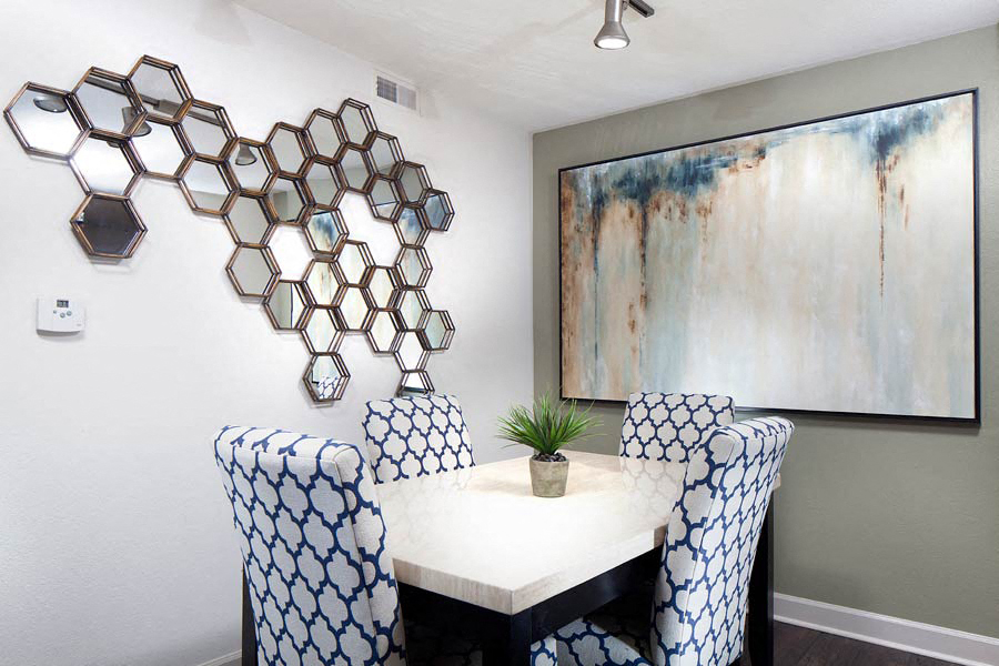 Ardenne Apartments Dining room with white table, blue and white chairs, grey walls and mirror art