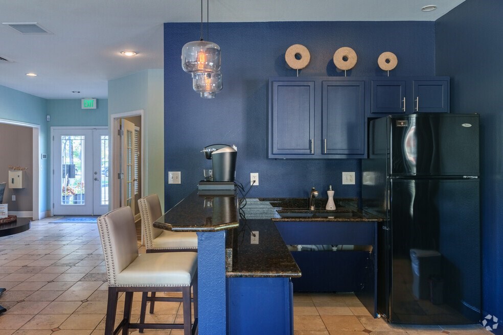 a kitchen with blue cabinets and a black counter top