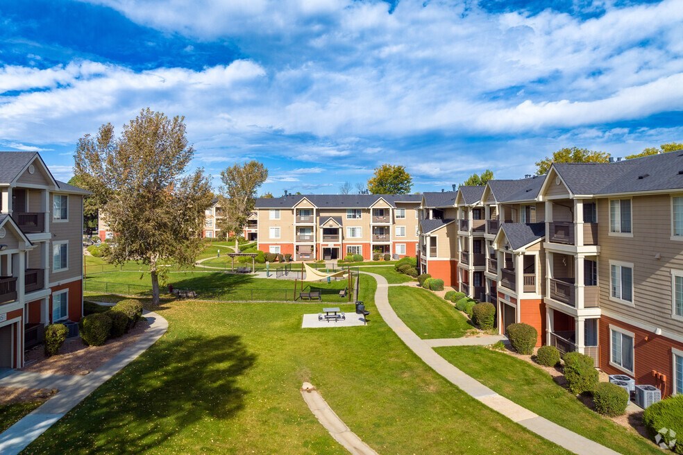 an aerial view of an apartment complex with green grass and trees