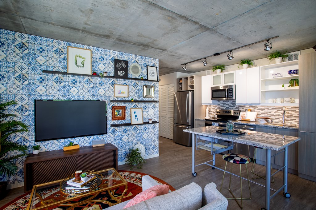 a kitchen and living room with blue and white tiles on the wall