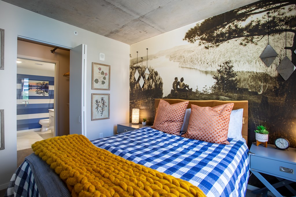 a bed with a blue and white checkered blanket and pillows in a