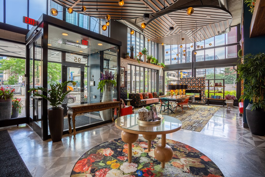 the lobby of a building with tables and chairs and large windows