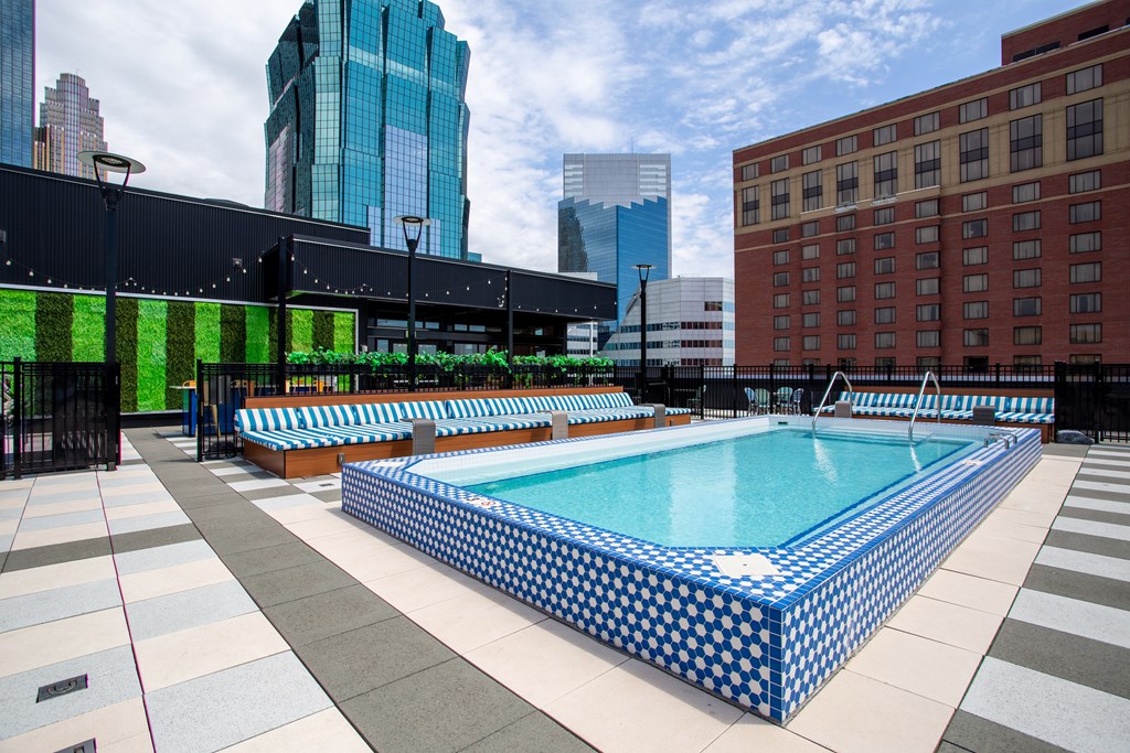 a pool on the rooftop of a building with skyscrapers