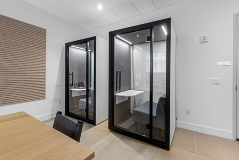 A modern kitchen with a wooden table and black fridge.