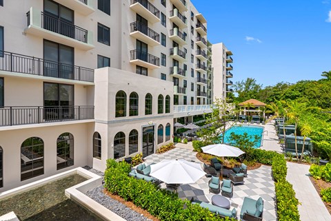 A large white building with a pool in front.