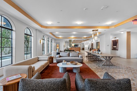 A spacious living room with a red carpet and a variety of seating options.