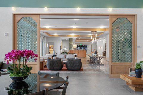 A room with a table and chairs in front of a glass door.