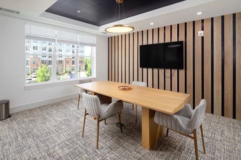 A conference room with a long table and chairs.
