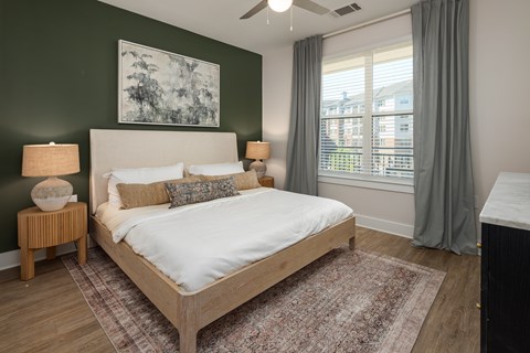 A bedroom with a large bed and a painting on the wall.