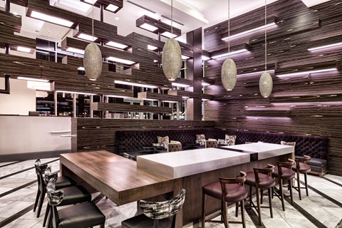 A modern dining area with a long wooden table and chairs.