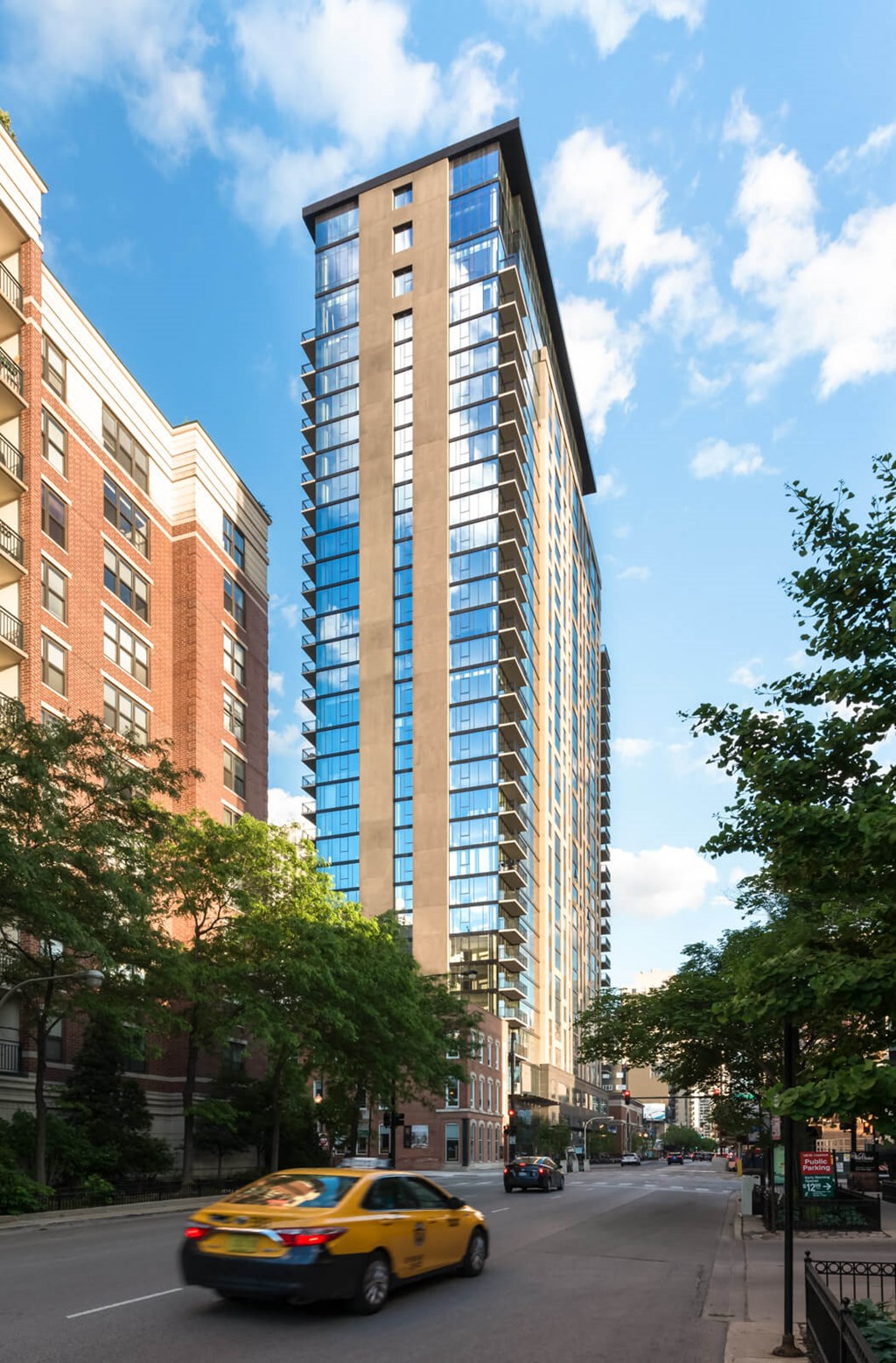a taxi driving down the street in front of a tall building