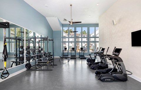 a gym with cardio equipment and windows in a building