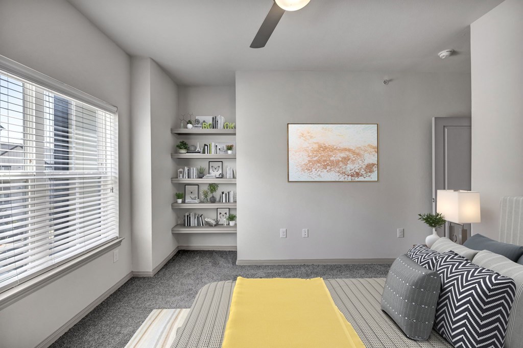 a living room with a large window and a yellow rug