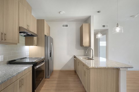 A kitchen with wooden cabinets and a granite countertop.