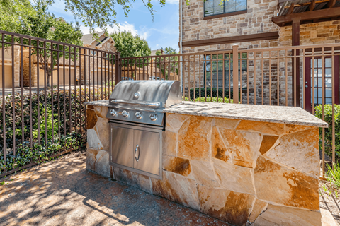 A stone wall with a metal grill on top.