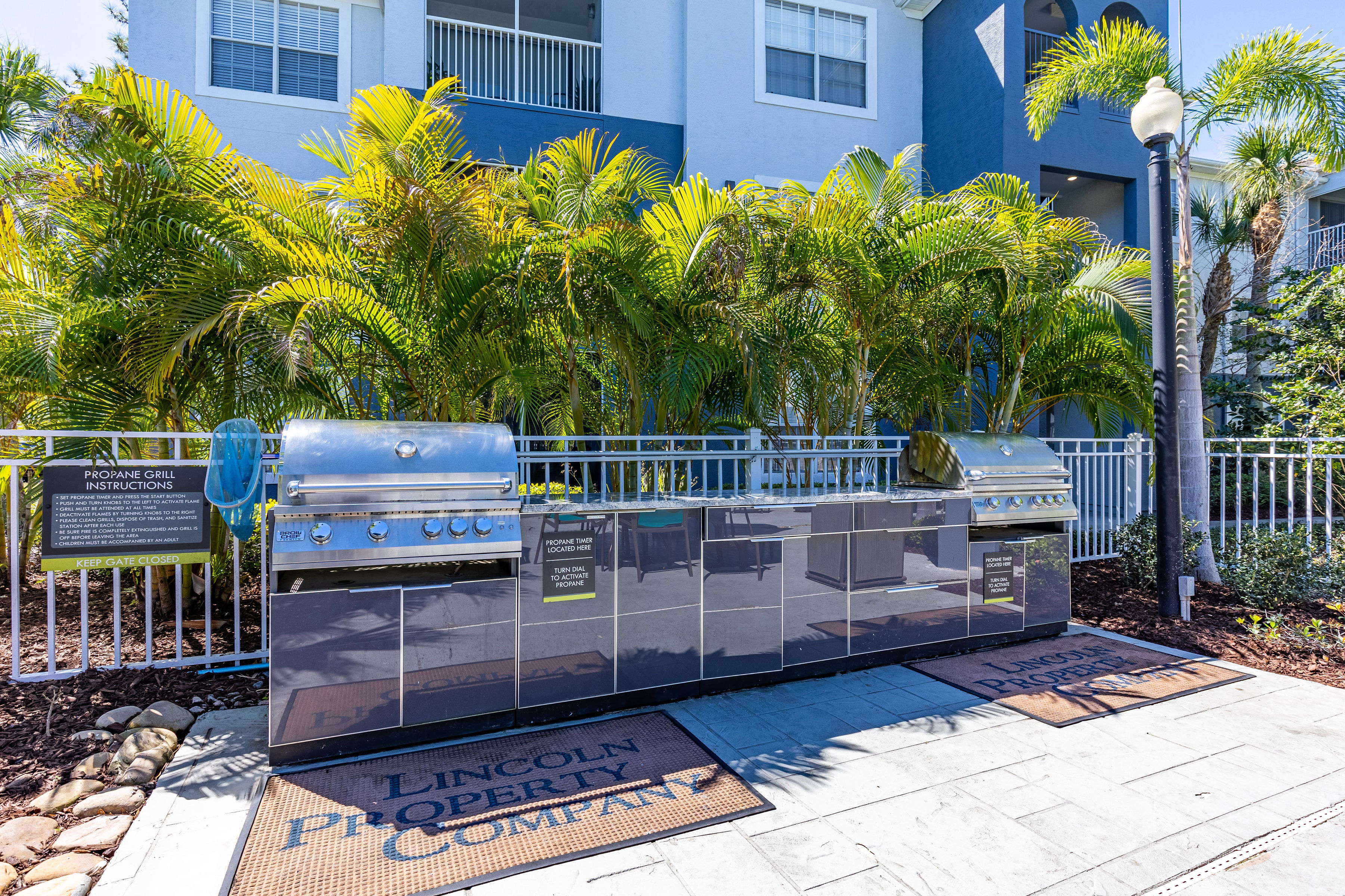 a stainless steel grill in front of a blue building