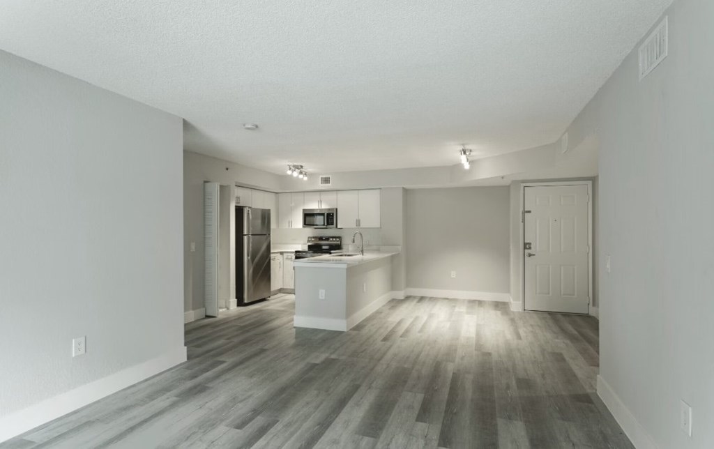 A spacious kitchen with a refrigerator, sink, and cabinets.