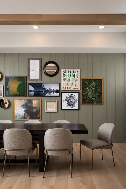 a dining room with a table and chairs and art on the wall